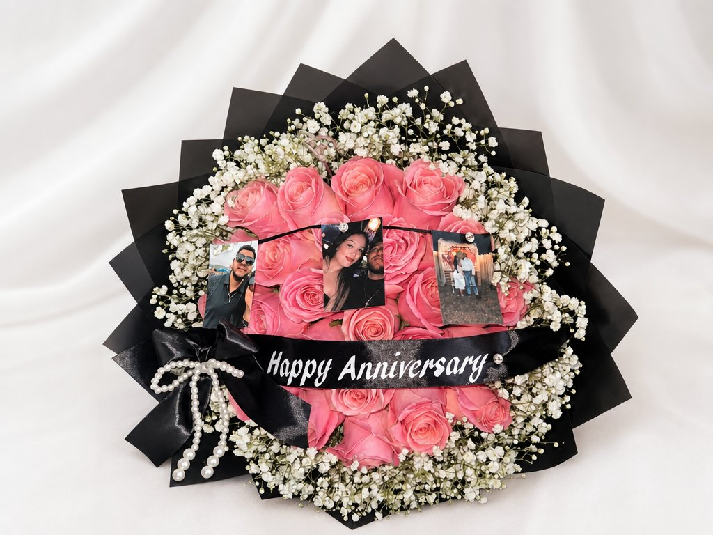 Pink roses and white baby's breath in a black star wrap with photos and a Happy Anniversary sash