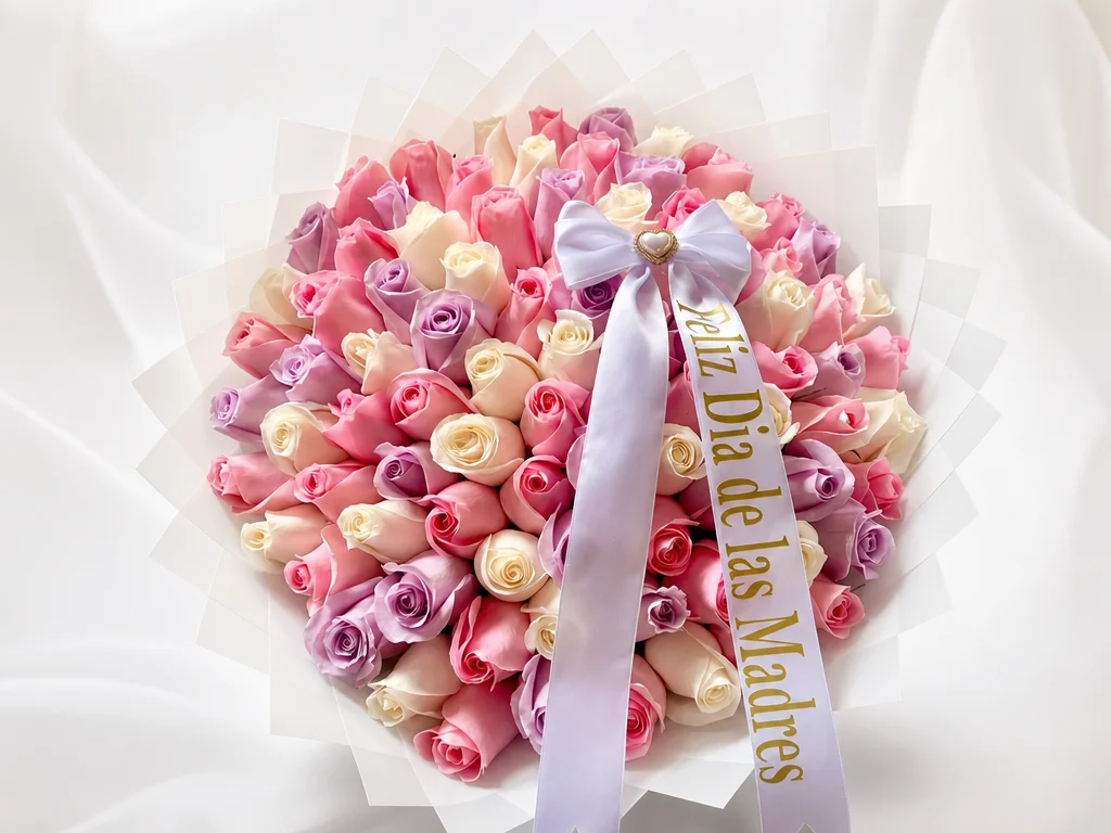 Dome of pink, lavender, and cream roses in white tissue with a Feliz Dia de las Madres sash