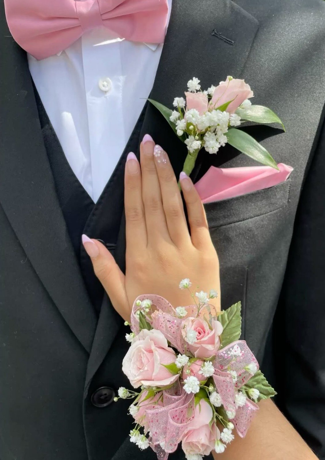 Pink rose corsage and boutonniere with baby's breath and sparkly ribbon