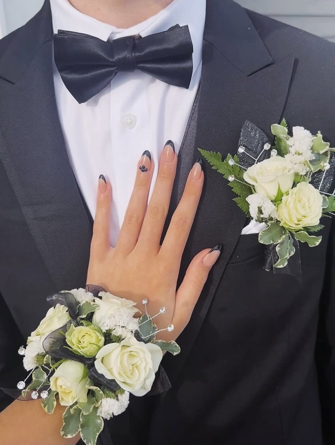 Ivory rose corsage and boutonniere with variegated greenery and rhinestone accents