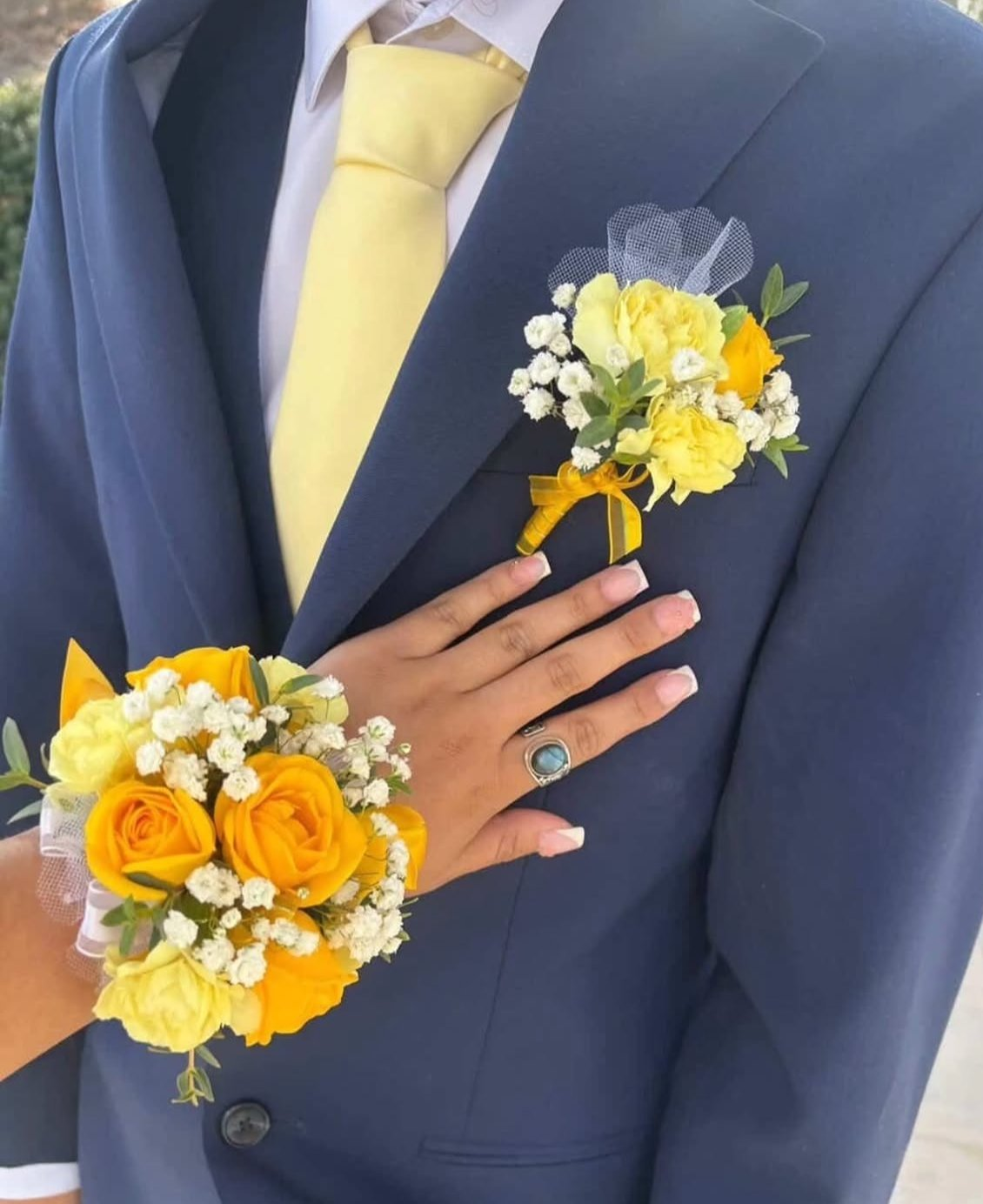 Matching yellow rose wrist corsage and lapel boutonniere with baby's breath